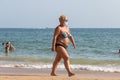 Punta Umbria, Huelva, Spain - August 7, 2020: Overweight woman walking by the beach wearing protective or medical face masks. New