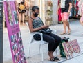 Punta Umbria, Huelva, Spain - August 7, 2020: A woman african migrant street side hair salon. Here the hairdresser is waiting for