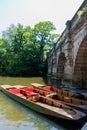 Punting boats by Magdalen Bridge Boathouse on river Cherwell in Oxford, many boats docked together in rows. Bright and colorfull Royalty Free Stock Photo