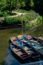 Punting boats by Magdalen Bridge Boathouse on river Cherwell in Oxford, many boats docked together in rows. Bright and colorfull