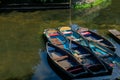 Punting boats by Magdalen Bridge Boathouse on river Cherwell in Oxford, many boats docked together in rows. Bright and colorfull