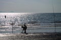Puntone Scarlino, Maremma Tuscany, Italy, Fisherman fishing at sunset while children playing around the beach