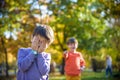 Pupil bullying another in the yard at the elementary school. Older boy offends younger kid. Laughing on his back. Small child Royalty Free Stock Photo