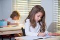 Pupil in classroom at school. Education, elementary school, learning and people concept - group of school kids with pens