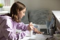 Teenage girl sanitize computer with antibacterial gel at home