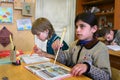 Pupil girl of initial classes meets lesson in rural school.