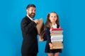 Pupil girl with pile of books ready to school. Hard to study. Father preparing backpack with school supplies for