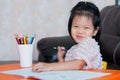 Pupil girl sweet smiling, looking at the camera. Happy student learning at home. Home school. Baby aged 4-5 year old