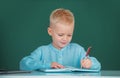 Pupil near chalkboard during lesson at primary school, close up portrait. Funny pupil of primary school study in Royalty Free Stock Photo