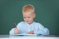 Pupil near chalkboard during lesson at primary school, close up portrait. Funny pupil of primary school study in Royalty Free Stock Photo