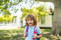 Pupil of primary school with book in hand. Schoolboy with backpack near school outdoors. Beginning of lessons. Royalty Free Stock Photo