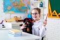 Pupil of primary school with funny dog against chalkboard. Nerd school girl with puppi in glasses smiling. Go back to