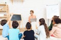 Pupil pulls his hand to answer teacher`s question in glasses at primary school.