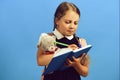 Pupil in school uniform with braids. Girl holds teddy bear Royalty Free Stock Photo