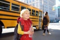 Pupil with schoolbag and bottle of water with yellow school bus on background Royalty Free Stock Photo