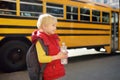 Pupil with schoolbag and bottle of water with yellow school bus on background Royalty Free Stock Photo