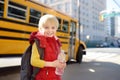 Pupil with schoolbag and bottle of water with yellow school bus on background Royalty Free Stock Photo