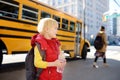 Pupil with schoolbag and bottle of water with yellow school bus on background Royalty Free Stock Photo