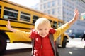 Pupil with schoolbag with yellow school bus on background Royalty Free Stock Photo