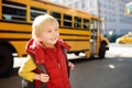 Pupil with schoolbag with yellow school bus on background Royalty Free Stock Photo