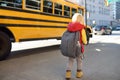 Pupil with schoolbag with yellow school bus on background Royalty Free Stock Photo