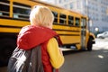 Pupil with schoolbag with yellow school bus on background Royalty Free Stock Photo