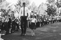 A pupil of the senior class and a girl first-grader with a bell in hands on a school solemn line in the day of knowledge, black a