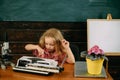 Pupil type on typewriter in school class. Elementary school pupil enjoy learning to typewrite