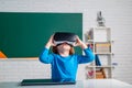 Pupil with vr goggles in school classroom. Little boy playing with VR glasses. Royalty Free Stock Photo