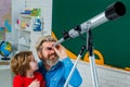 Pupil watching stars with a teacher. Astronomy telescope. Elementary school.