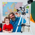 Pupil watching stars with a teacher. Astronomy telescope. Father teaching son.