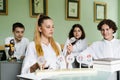 Pupils at biology lesson at school with animal cell models on the table. Biology teacher gives a lesson to Royalty Free Stock Photo