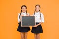 Pupils community. School schedule. School girls cute pupils hold blackboard copy space. School announcement concept