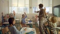 Pupils learning in classroom. Male teacher asking questions at lesson