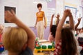 Pupils Raising Hands To Answer Question In Elementary School Maths Lesson Royalty Free Stock Photo