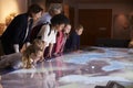 Pupils On School Field Trip To Museum Looking At Map Royalty Free Stock Photo