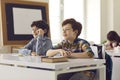 Portrait of two elementary school boys sitting in class and listening to the teacher. Royalty Free Stock Photo