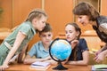 Pupils studying a globe together with teacher Royalty Free Stock Photo