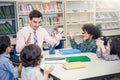 Pupils Studying with teacher At Desks In Classroom,