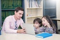 Pupils studying with teacher using computer device in classroom Royalty Free Stock Photo