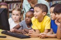 Pupils and teacher in the library using computer Royalty Free Stock Photo