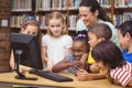 Pupils and teacher in the library using computer Royalty Free Stock Photo