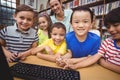 Pupils and teacher in the library using computer Royalty Free Stock Photo