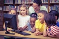 Pupils and teacher in the library using computer Royalty Free Stock Photo