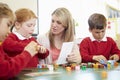 Pupils And Teacher Working With Coloured Blocks Royalty Free Stock Photo