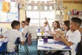 Pupils turning round in lesson at primary school, side view