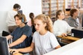 Pupils using computers at lesson, teacher teaching them in class room Royalty Free Stock Photo