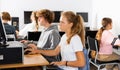 Pupils using computers at lesson, teacher teaching them in class room Royalty Free Stock Photo