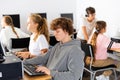 Pupils using computers at lesson, teacher teaching them in class room Royalty Free Stock Photo