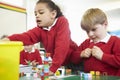 Pupils Working With Coloured Blocks In Maths Lesson Royalty Free Stock Photo